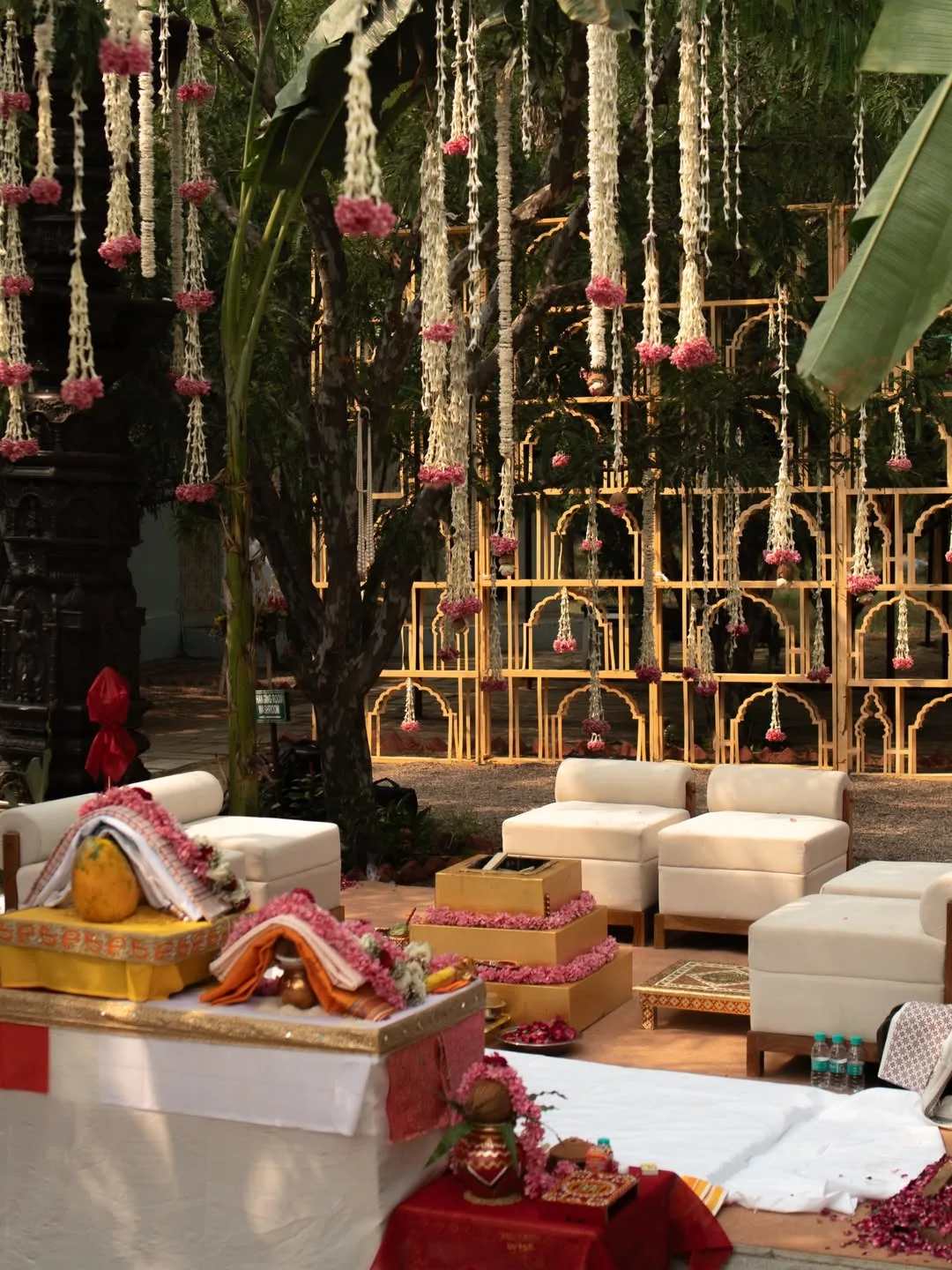 Wedding mandap with hanging marigold and rose strings nestled among temple pillars at a sundowner wedding